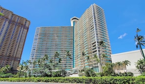 Stunning hotel complex with a sleek, contemporary design, featuring a central building with balconies and lush greenery.