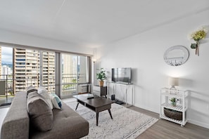 Enjoy a comfortable stay in this apartment with a spacious living area, floor-to-ceiling windows, and a flat-screen TV.