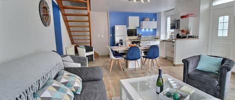 Een modern appartement met een woonkamer, eetgedeelte, keuken en een trap.