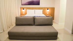Een moderne hotelkamer met een groot bed, twee nachtkastjes en een kunstwerk aan de muur.