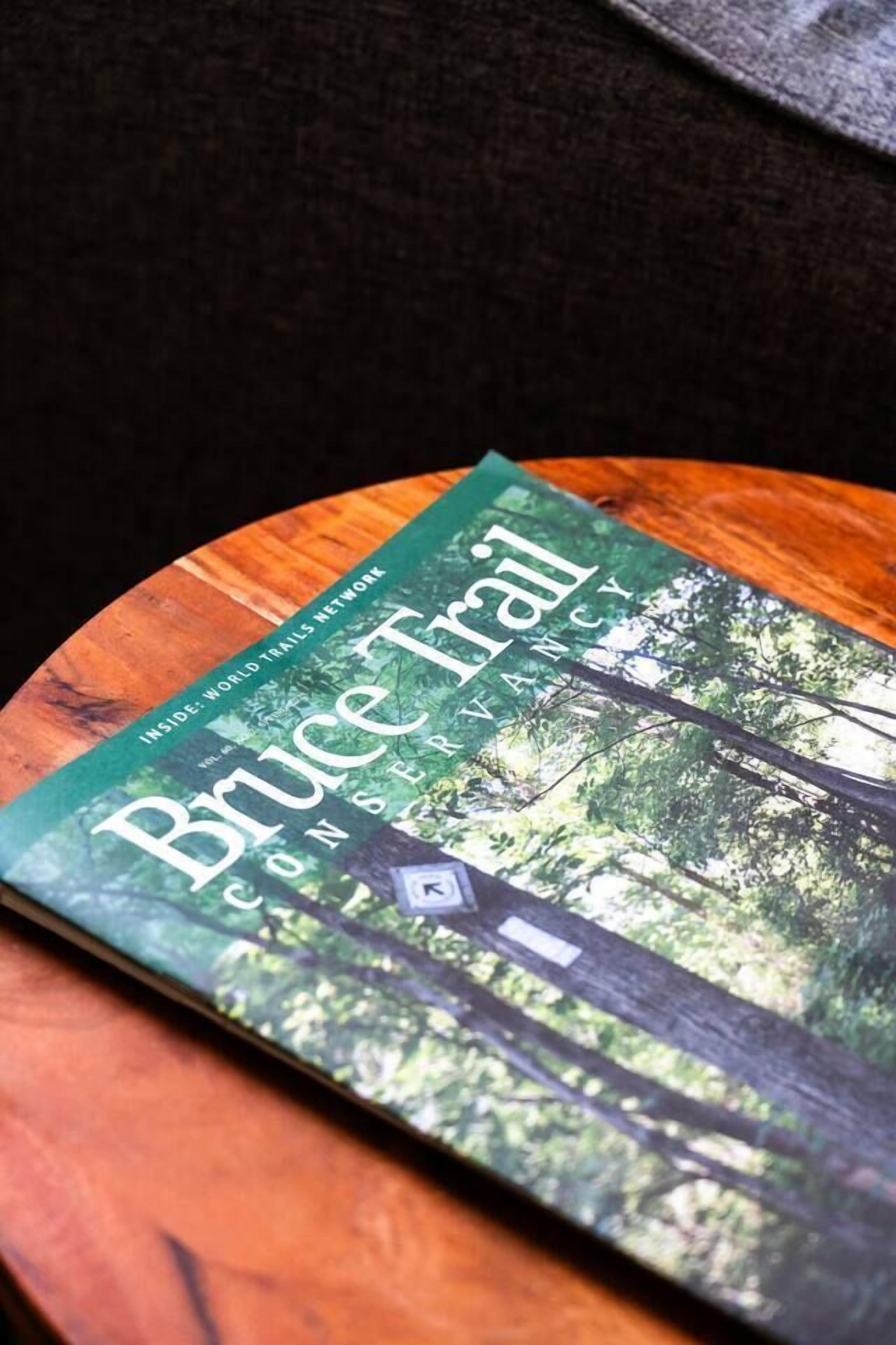 En bok med titeln ”Bruce Trail” ligger på en träyta.