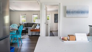 Una cocina moderna con comedor, un sofá y un cuadro en la pared.