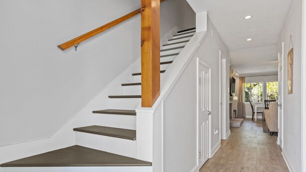 Eine Treppe mit hölzernen Geländern und weißen Wänden.