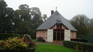 Een traditioneel huis met een steile dakschild, een schoorsteen en een grote houten deur.
