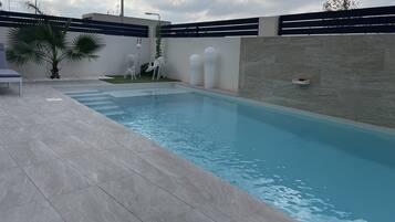 Una piscina al aire libre, una piscina climatizada