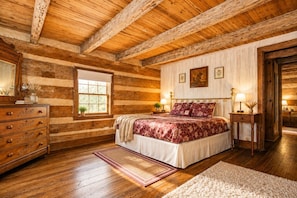 Een slaapkamer in een blokhut met een bed, een dressoir en een raam.