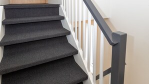 A staircase with a wooden door and a black railing. - Hrimland Guesthouse (Akureyri)