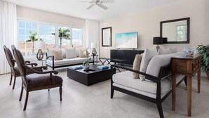 Una sala de estar moderna con un sofá, sillones, una mesa de centro y un televisor.