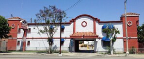 A two-story motel with a red and white facade, a clear entrance, and a blue awning over the door. - Royal Inn Motel, Compton CA (Compton)