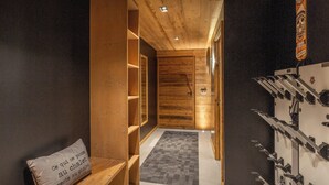 A wooden interior hallway with a bench, a shoe rack, and a door leading to another room. - Chalet Mevi - family break in the Alps 13p, great location - OVO Network (Crest-Voland)
