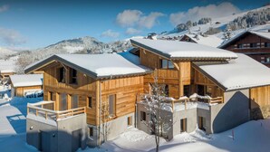 A wooden chalet with a balcony, surrounded by snow-covered mountains. - Chalet Mevi - family break in the Alps 13p, great location - OVO Network (Crest-Voland)
