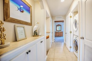 A hallway with a framed picture, a decorative bird, and a framed quote on the wall.