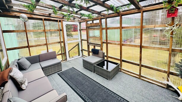 Un patio techado con un sofá, una mesa de centro y una alfombra.