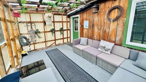 Un espacio al aire libre acogedor con un porche de madera, bancos acolchados y un adorno decorativo.