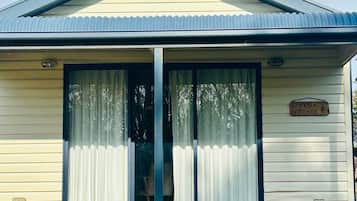 Welcome to Banksia Cottage, a charming single-story retreat with a gabled roof and deck.