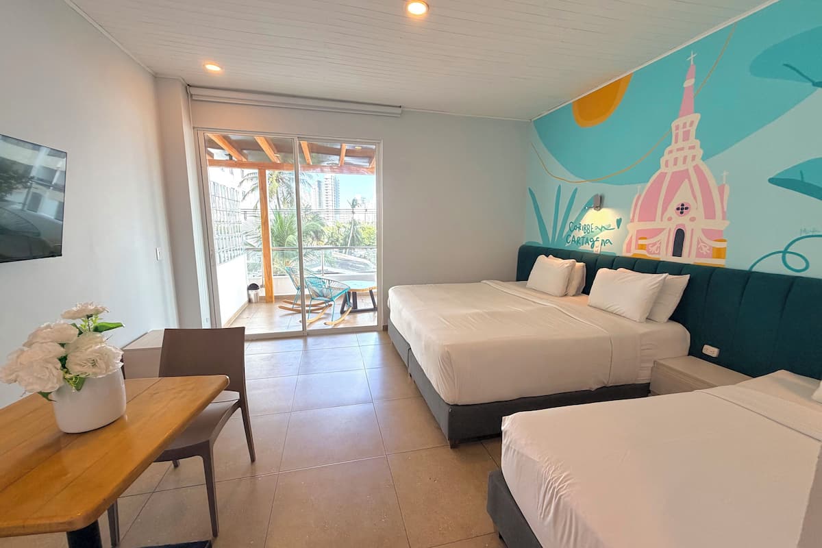 Ein Hotelzimmer mit Balkon, einem Bett, einem Schreibtisch mit Stuhl und Wandbild.