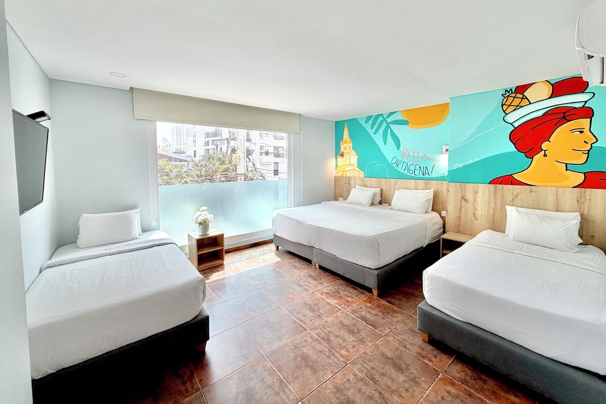 Ein Hotelzimmer mit zwei Betten, einem großen Fenster und einem Wandgemälde.