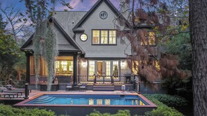 A large house with a swimming pool, a deck, and a covered patio area.