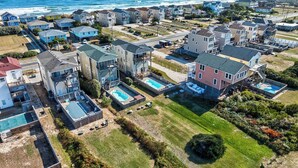Una zona residenziale lungo la costa, con case, spiaggia e molo.