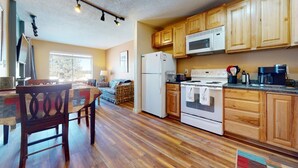 A kitchen with wooden cabinets, a refrigerator, a stove, and a microwave. - Walk to Lifts | Views | Fireplace | Bella Vista E1 (Angel Fire)