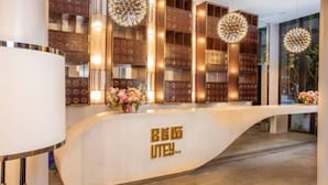 A reception desk with a modern design, featuring a curved white counter and gold accents. - UTEY HOTEL (Siem Reap)