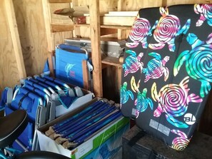 A room with a blue wheelchair, a colorful chair, and a box labeled "Fabric Beach Cushion."