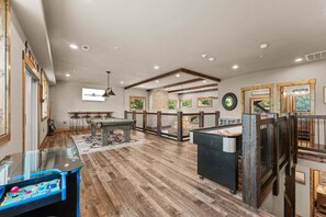 A spacious indoor area with a pool table, a ping pong table, and a billiards table.