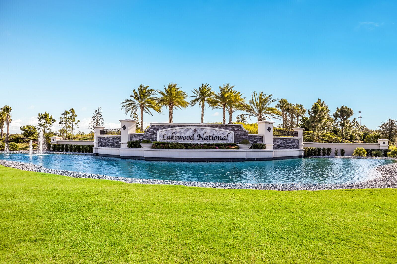 A sign for Lakewood National with a pool and palm trees in the background.