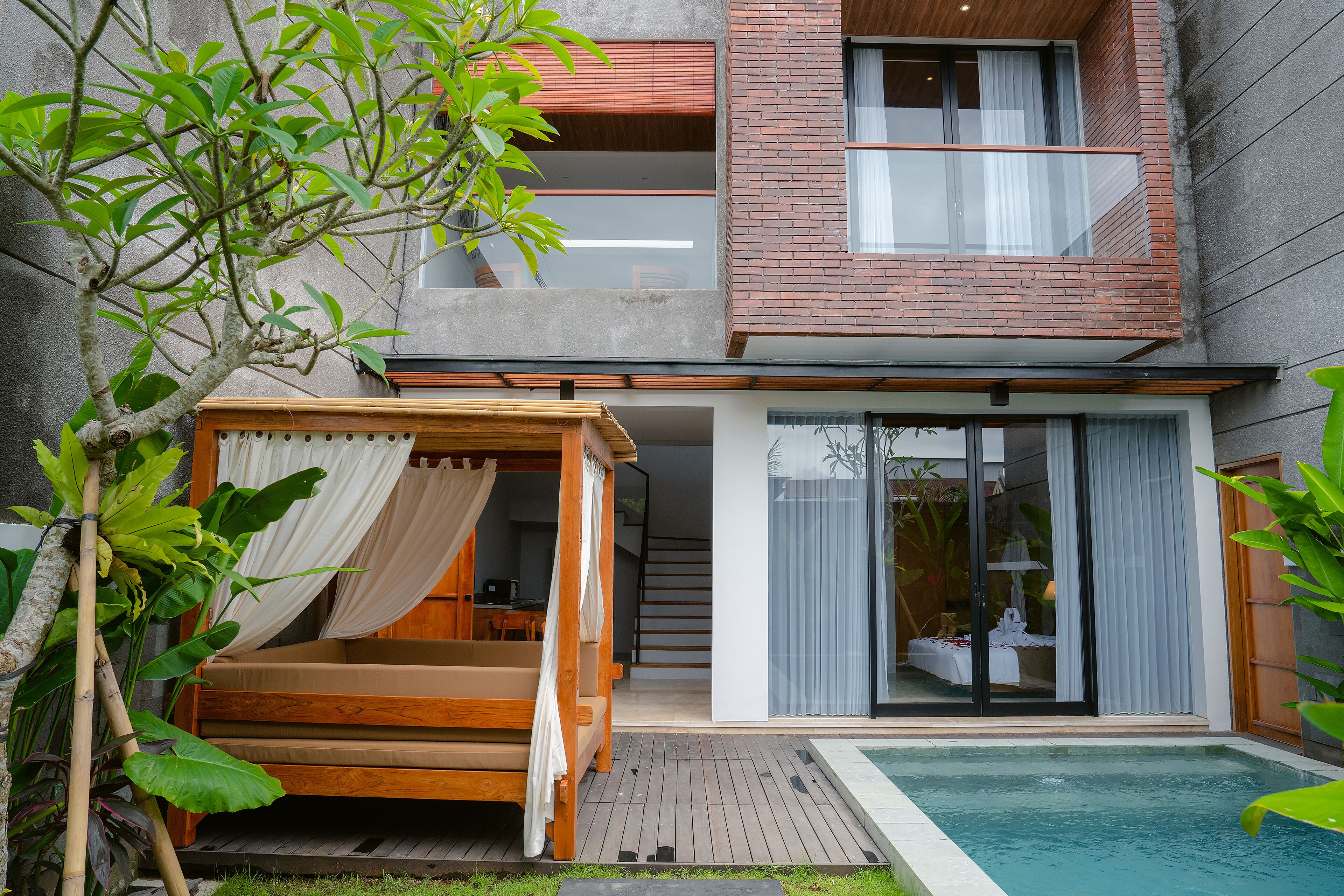 Una casa moderna de dos pisos con una cama de madera, piscina y balcón.