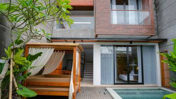 Una casa moderna de dos pisos con una cama de madera, piscina y balcón.