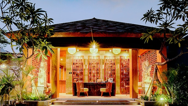 A traditional wooden building with a reception desk, chairs, and decorative lanterns. - Villa Bulan Bali (Jimbaran)