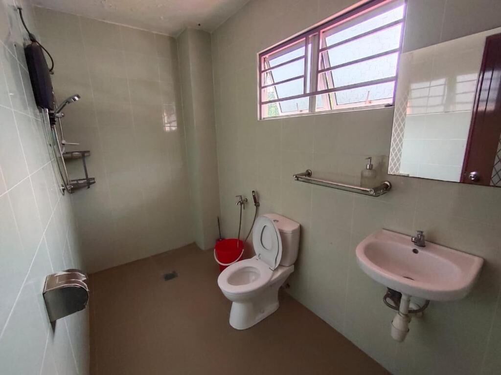 A bathroom with a toilet, sink, and shower.