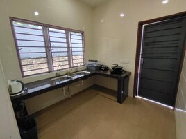 Cocina compacta con lavamanos, estufa y ventana con vistas panorámicas.