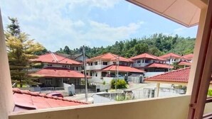 A balcony with a view of a residential area with red-roofed houses. - MUTIARA HEIGHT HOMESTAY  (Bentong)