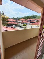 Un balcón con vistas a una zona residencial con casas de tejados rojos.