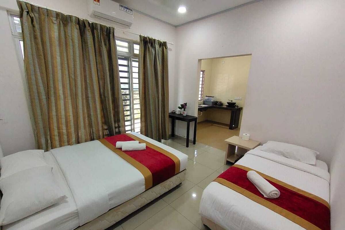 A hotel room with two beds, a desk, and a mirror.