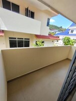 Un edificio de varios pisos con techo plano, ventanas grandes y un balcón.