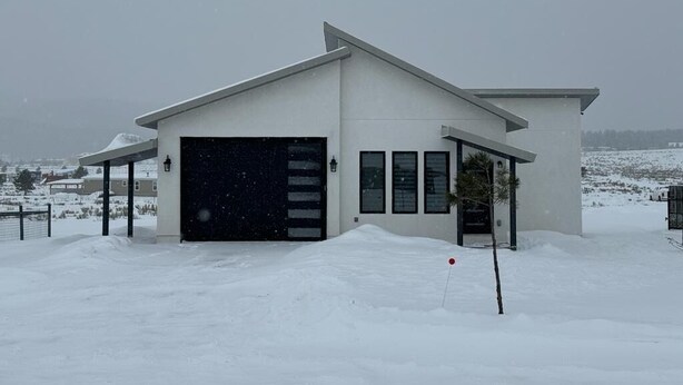 Ein modernes Haus mit Garage, umgeben von Schnee.
