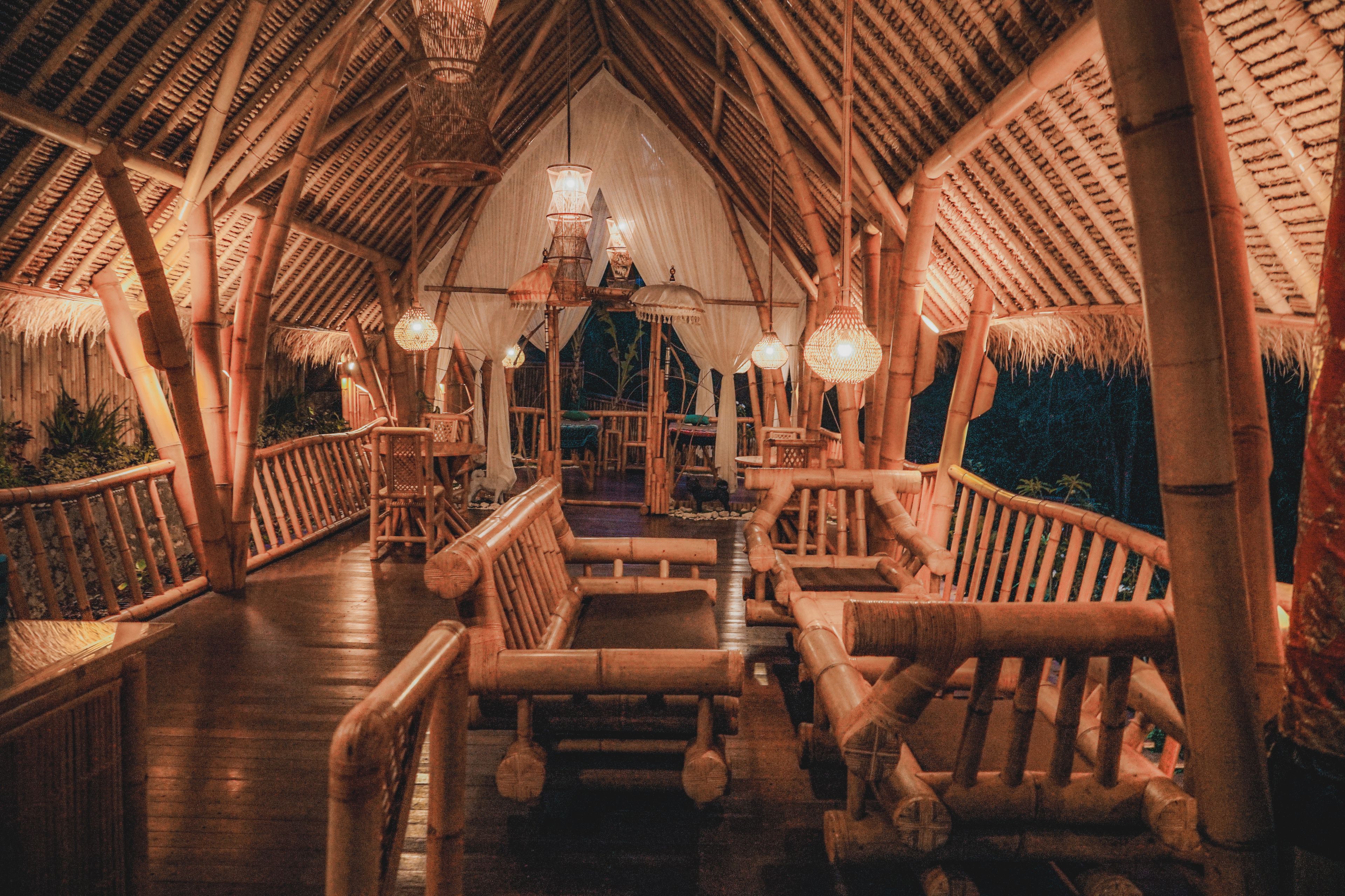 An interior with a high, arched ceiling and bamboo furniture.