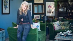 A room with a green sofa, a small table with a teapot, and various framed artworks on the walls. - Unique Boutique luxury Bed and Breakfast (Chichester)