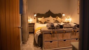 A bedroom with a bed, bedside lamps, and a wooden headboard. - Unique Boutique luxury Bed and Breakfast (Chichester)