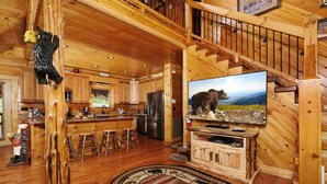 A wooden cabin interior with a kitchen, bar area, and a large bear statue on the wall. - A Cloud 9 - Mountain Views, Hot Tub Bliss & Pool Table Fun! (Sevierville)