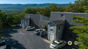 Un quartier résidentiel comprenant plusieurs maisons, un parking et un paysage montagneux en arrière-plan.