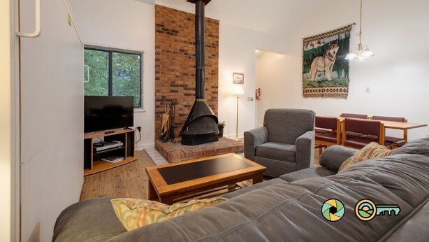 Ein Wohnzimmer mit Kamin, Fernseher, einer Couch und einem Essbereich.