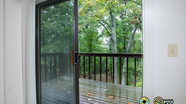 A room with a sliding glass door leading to a wooden deck with a metal railing. - Woodland Retreat (#97B) | Quiet area | Minutes to Bryce Resort! (Basye)