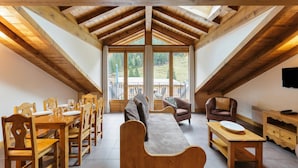 A dining area with wooden furniture, a bench, and a TV on the wall.