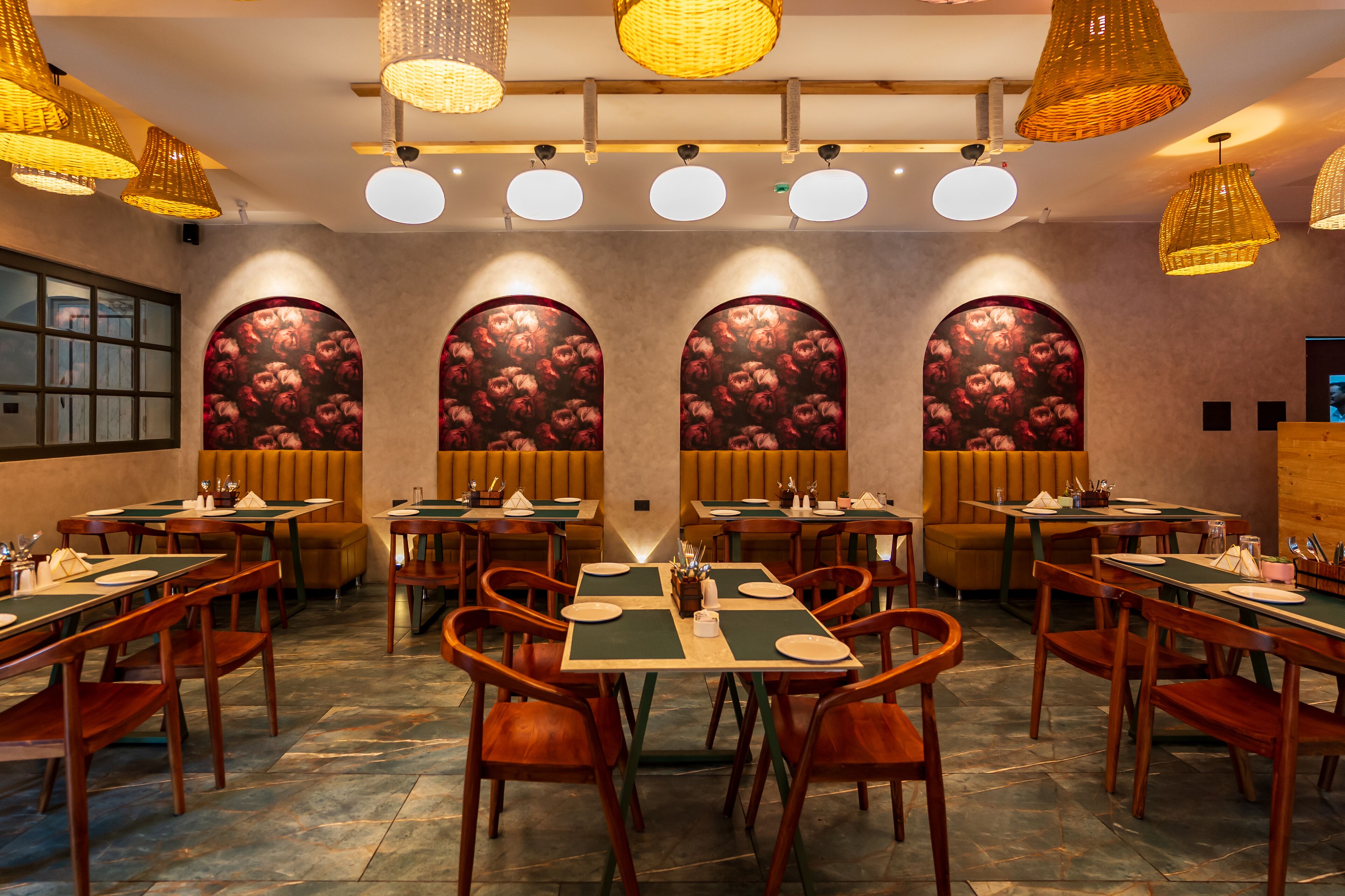 A restaurant with multiple tables and booths, warm lighting, and decorative wall panels.