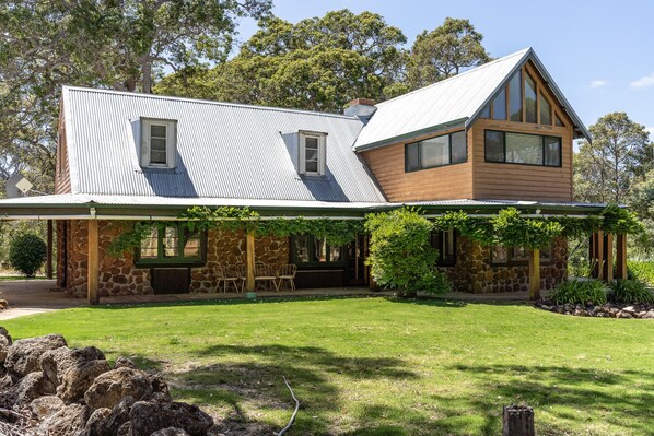 A two-story house with a stone facade, a metal roof, and a wooden extension. - Casa Rua | Margaret River (Witchcliffe)