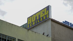 Une enseigne d’hôtel portant l’inscription « HÔTEL GEMILANG » est fixée à un bâtiment.