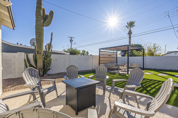 An outdoor patio with a table and chairs, a cactus, and a palm tree. - Old Town Retreat • Luxe Pool & Outdoor Space for Relaxing Getaways (Scottsdale)